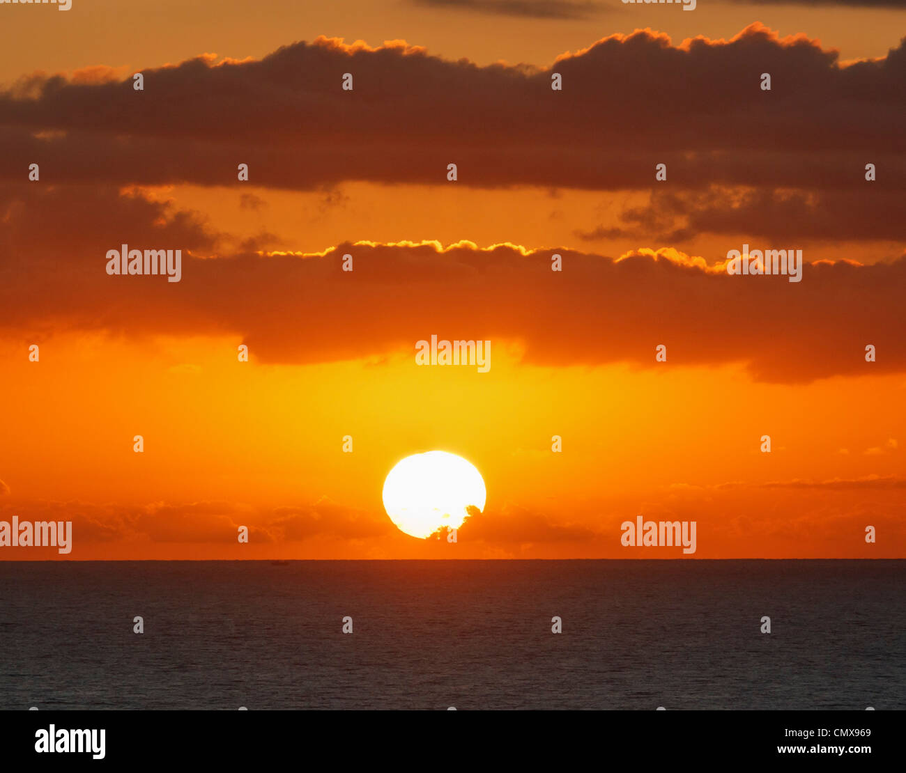 Lever du soleil à travers les nuages sur la mer Banque D'Images