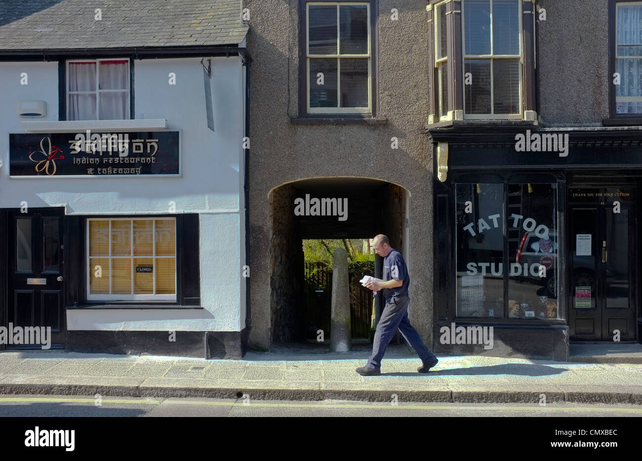 Un restaurant indien à emporter et à côté d'un salon de tatouage à Helston , Cornwall. Banque D'Images