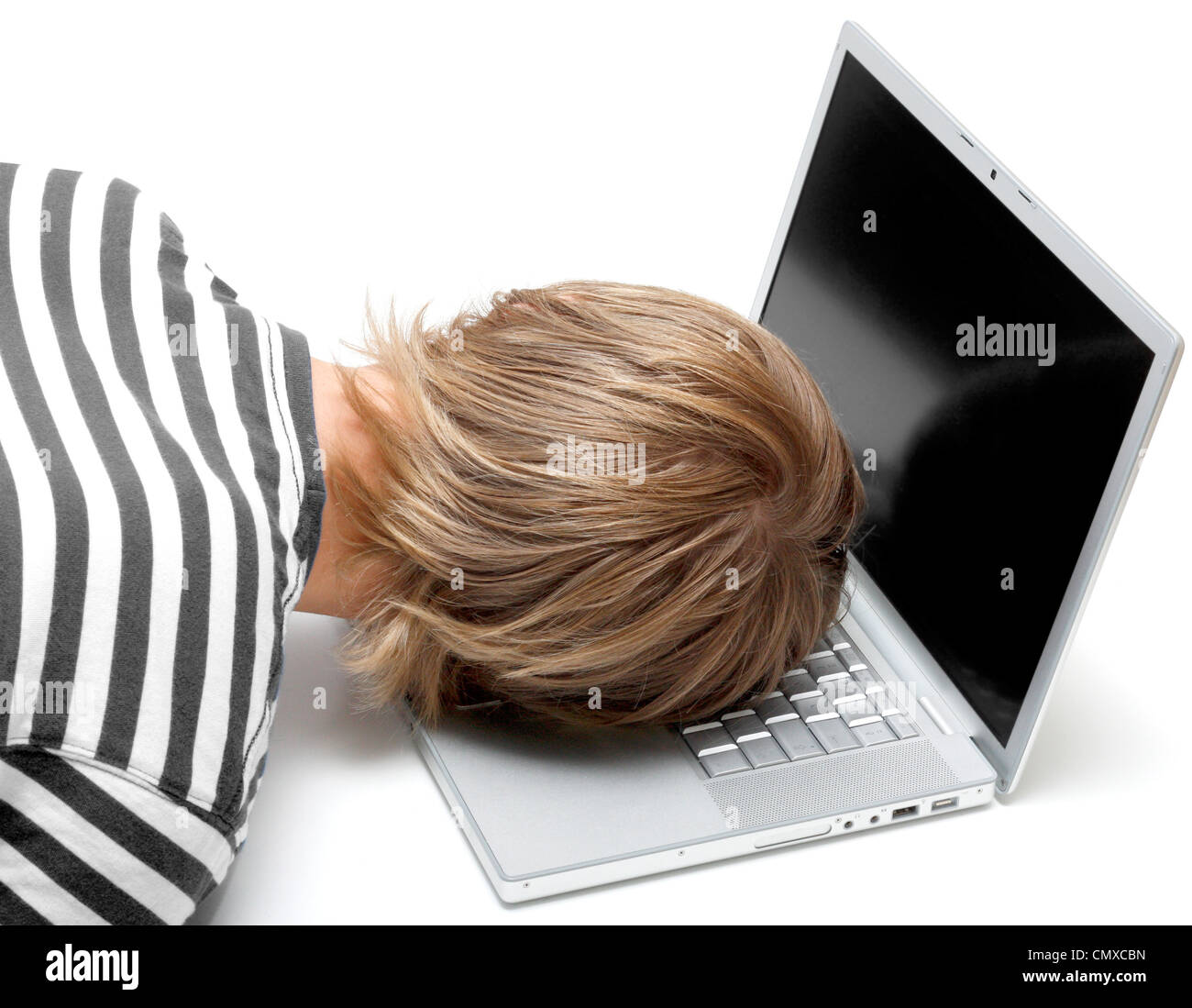Un homme dormant sur son ordinateur portable Banque D'Images