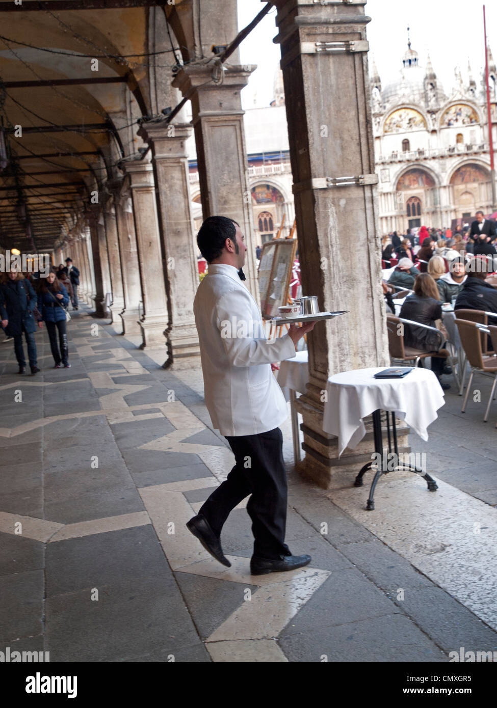 Un garçon porte un plateau de boissons sur la Piazza San Marco, Venise Banque D'Images