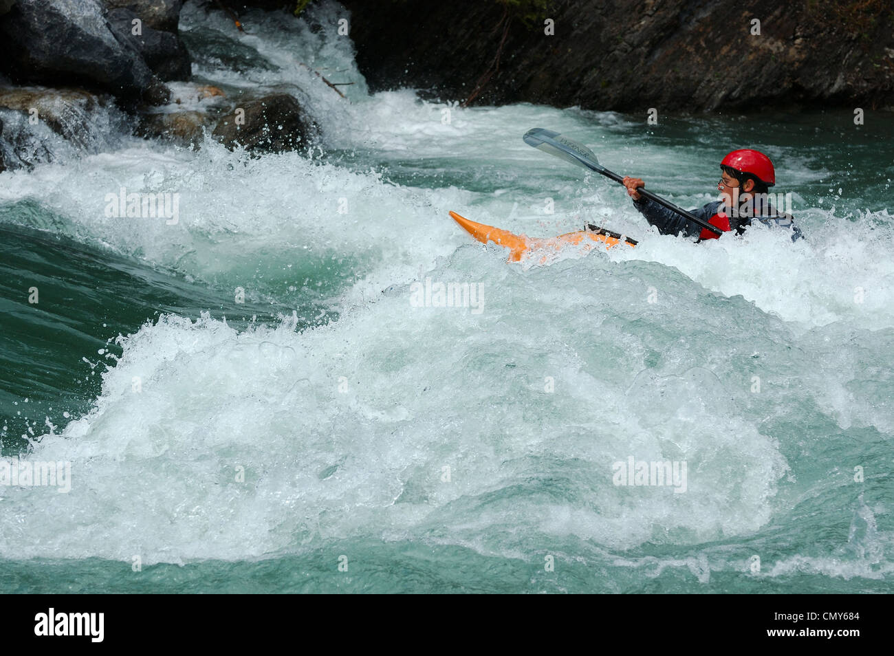 La kayakiste pagaie dans l'en-tête en mousse sur l'amont de la rivière Kananaskis, Alberta Canada Canoe Meadows Banque D'Images