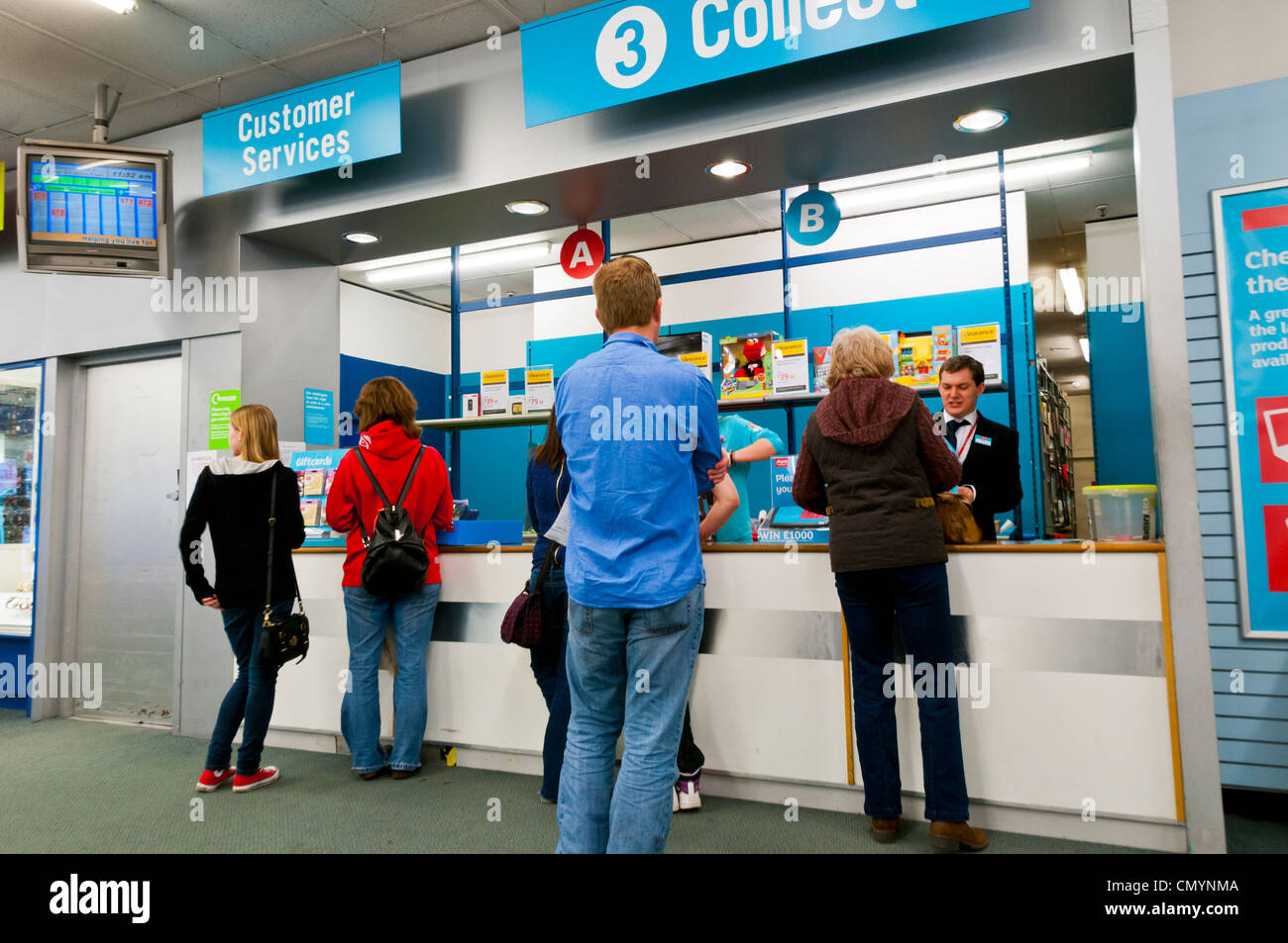 Les gens qui attendent pour recueillir leurs achats au point de collecte Argos, UK Banque D'Images