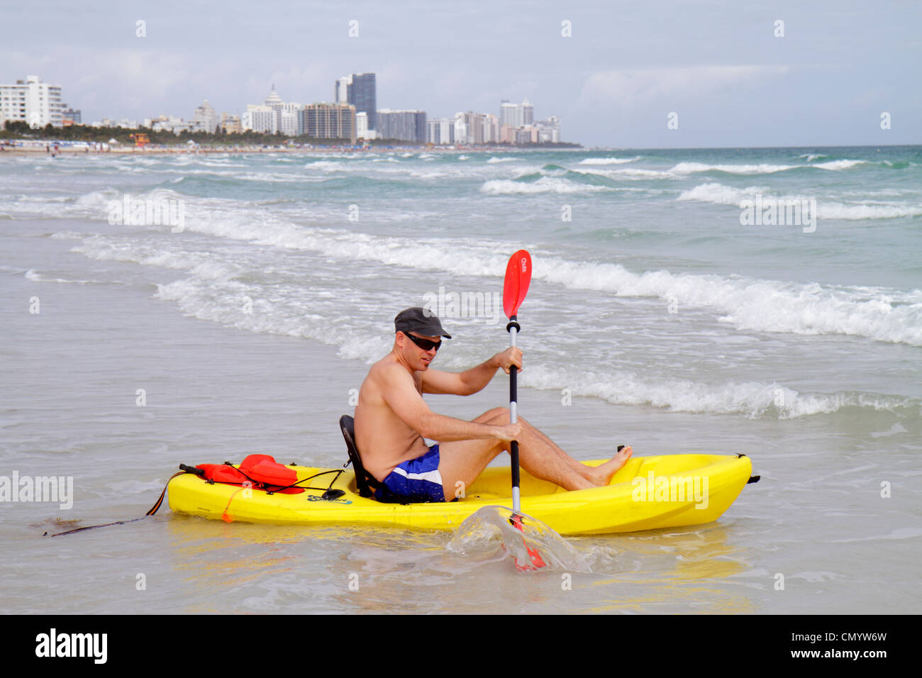 Miami Beach Florida,Atlantic Ocean Water Shore,surf,vagues,eau,homme hommes adultes,maillot de bain,jaune polyéthylène plastique océan kayak,draggin Banque D'Images
