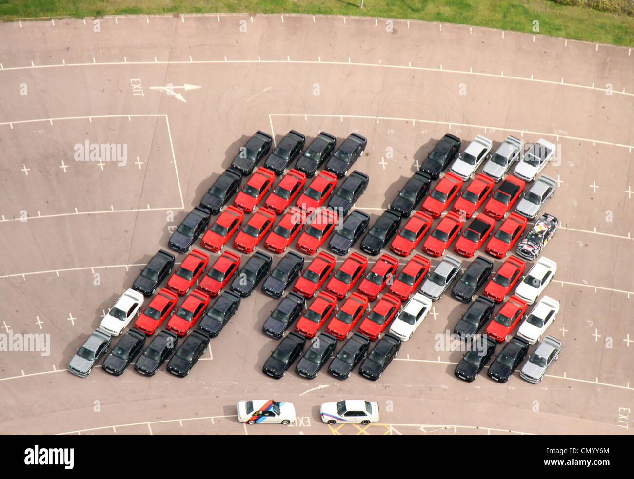 Vue aérienne de 66 voitures BMW Série M3 disposés en forme d'un M d'émuler une image acquise en Allemagne, il y a des décennies. Banque D'Images