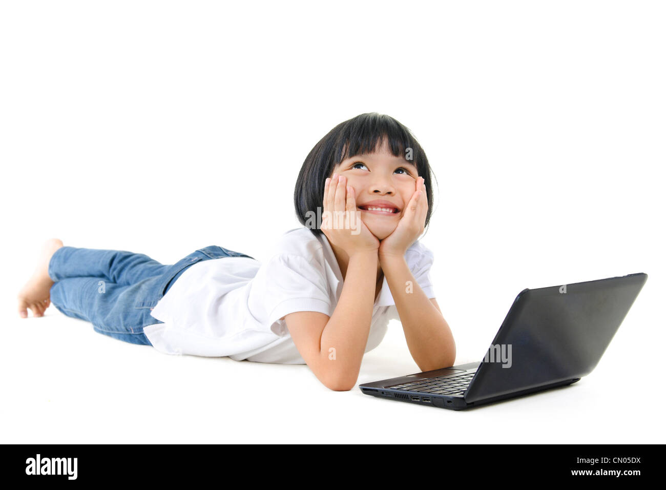 Pan Asian school girl using laptop and looking up Banque D'Images