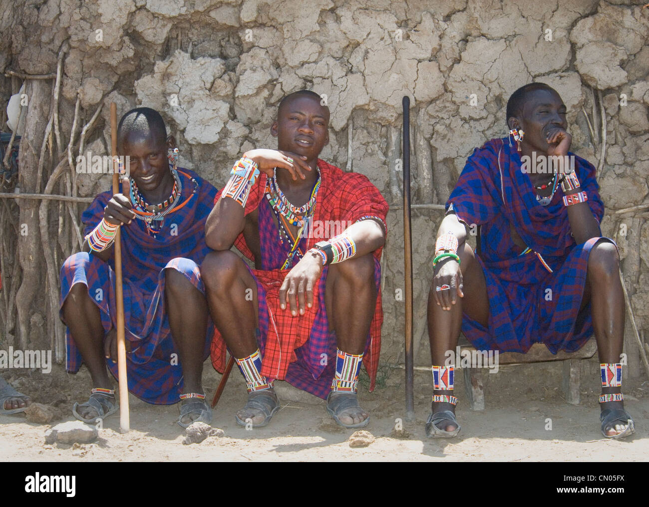 Trois hommes assis par manyatta Masaï Banque D'Images