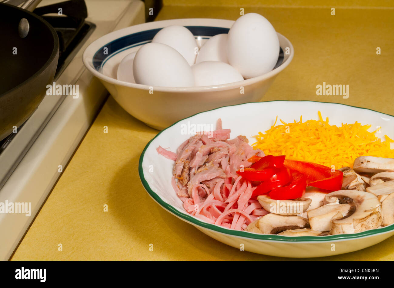 Ingrédients pour faire une omelette : œufs, fromage, jambon, champignons, des tranches de poivrons Banque D'Images