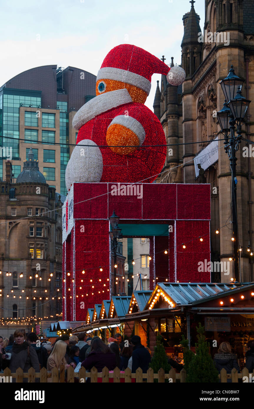 Le père Noël au-dessus des étals du marché de Noël à l'extérieur de l'hôtel de ville, Albert Square, Manchester, Angleterre, RU Banque D'Images