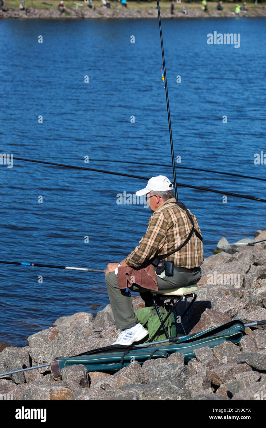 Pêcheur senior isolé aux championnats nationaux finlandais de pêche à la ligne 2011 au canal Kansola Saimaa. Série de vétérans (60+). , Finlande Banque D'Images