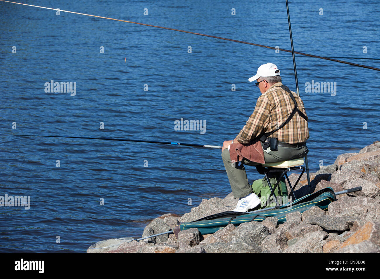 Pêcheur senior isolé aux championnats nationaux finlandais de pêche à la ligne 2011 au canal Kansola Saimaa. Série de vétérans (60+). , Finlande Banque D'Images