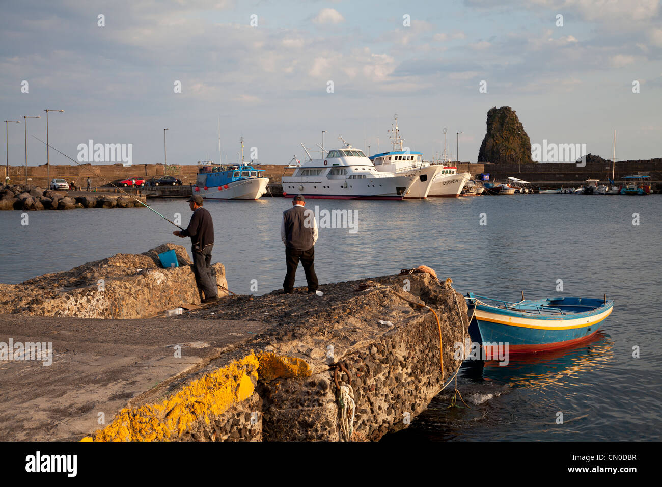 Le port de pêche de Aci Trezza avec les faraglioni dei Ciclopi au-delà Banque D'Images