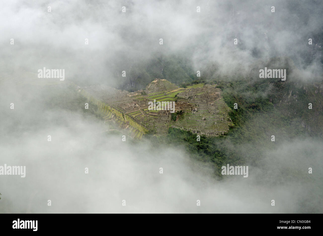 Le village Inca de Machu Picchu vu de la Porte du Soleil à travers un trou dans les nuages Banque D'Images