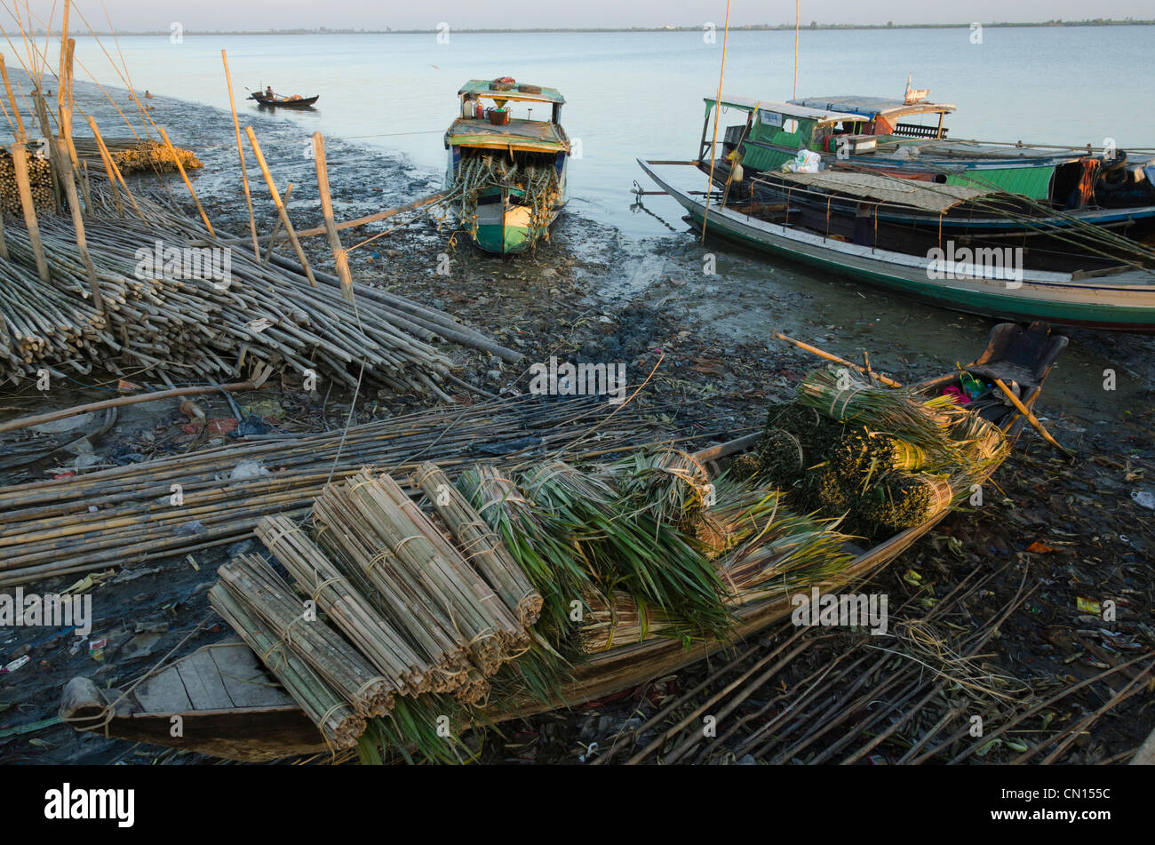 Produits de bambou sur de petits bateaux à marée basse dans le port de Labutta. Delta de l'Irrawaddy. Le Myanmar. Banque D'Images