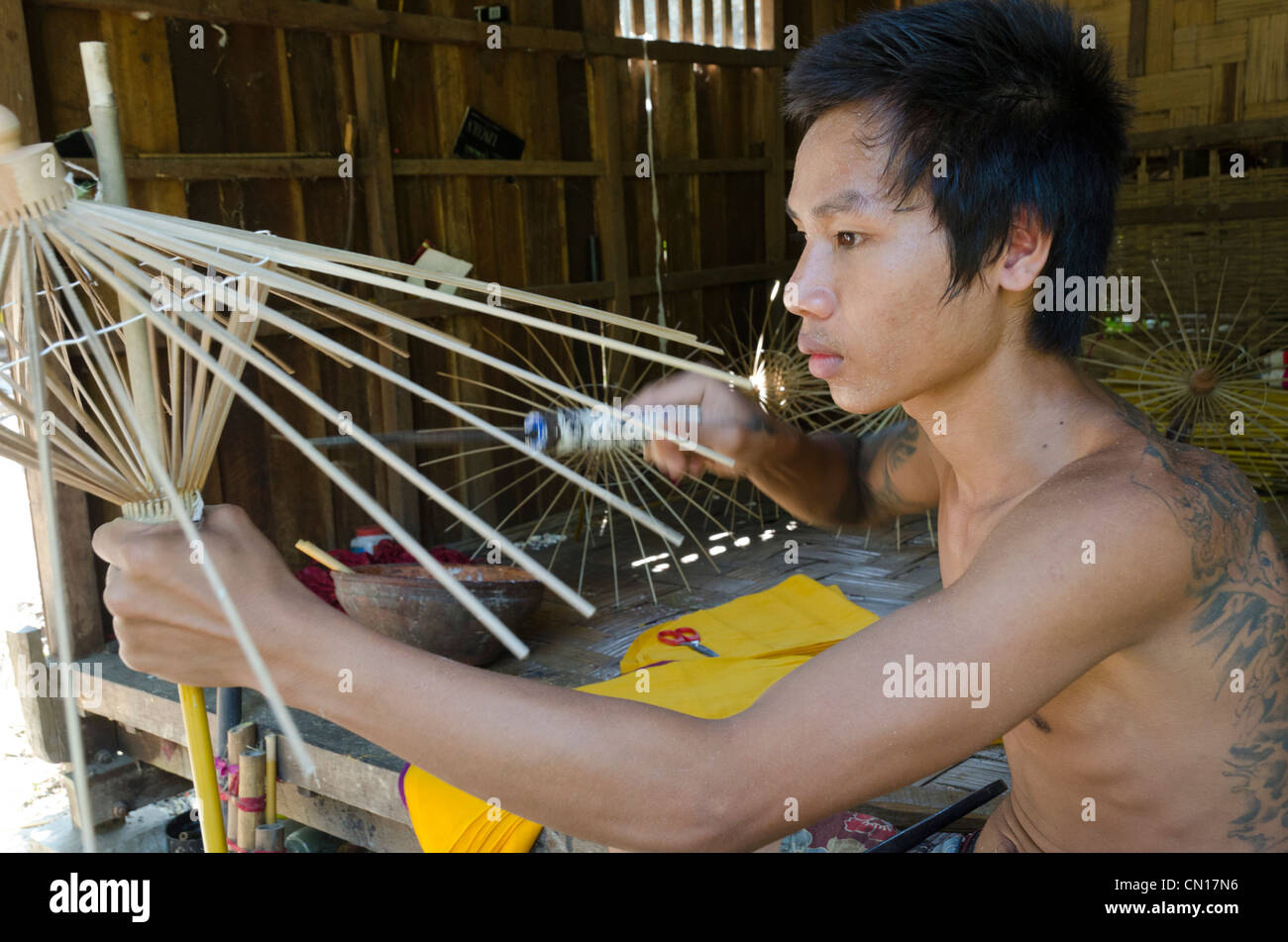 L'homme au travail à l'atelier d'un parapluie. Pathein. Delta de l'Irrawaddy. Le Myanmar. Banque D'Images
