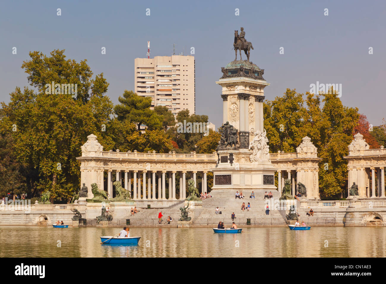 Madrid, Espagne. De l'aviron sur l'Estanque, ou d'un lac, dans les jardins d'El Retiro. Monument au roi Alphonse XII en arrière-plan. Banque D'Images