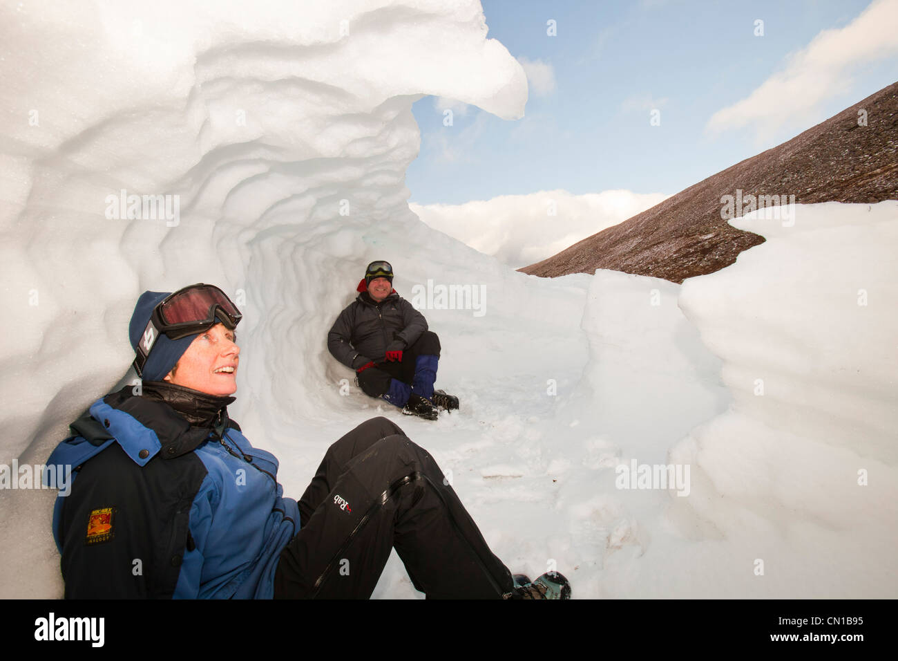 Les alpinistes à l'abri dans un trou à neige dans les montagnes de Cairngorm, Ecosse, Royaume-Uni. Banque D'Images