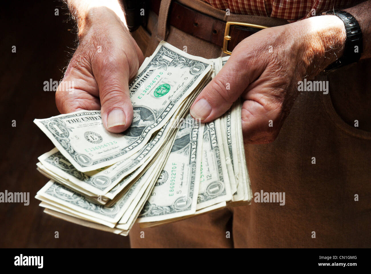 Older Man's Hands Holding Dollar Bills Banque D'Images