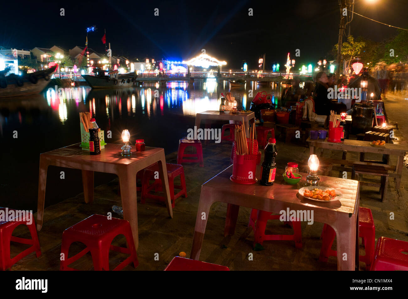 Des stands de nourriture de rue par la rivière Thu Bon éclairé la nuit avec des lanternes, Hoi An, Vietnam Banque D'Images