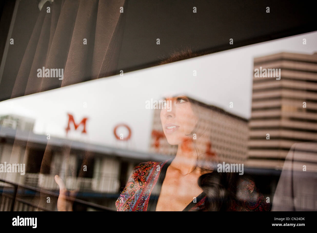Jeune femme en fenêtre motel Banque D'Images