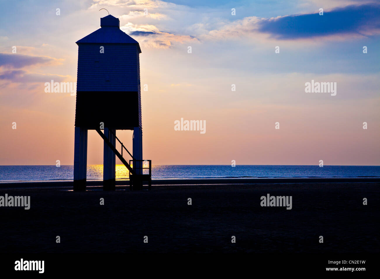 Un contre jour tourné contre la lumière de l'inhabituelle phare sur pilotis à Burnham-on-Sea, Somerset, England, UK, au coucher du soleil. Banque D'Images