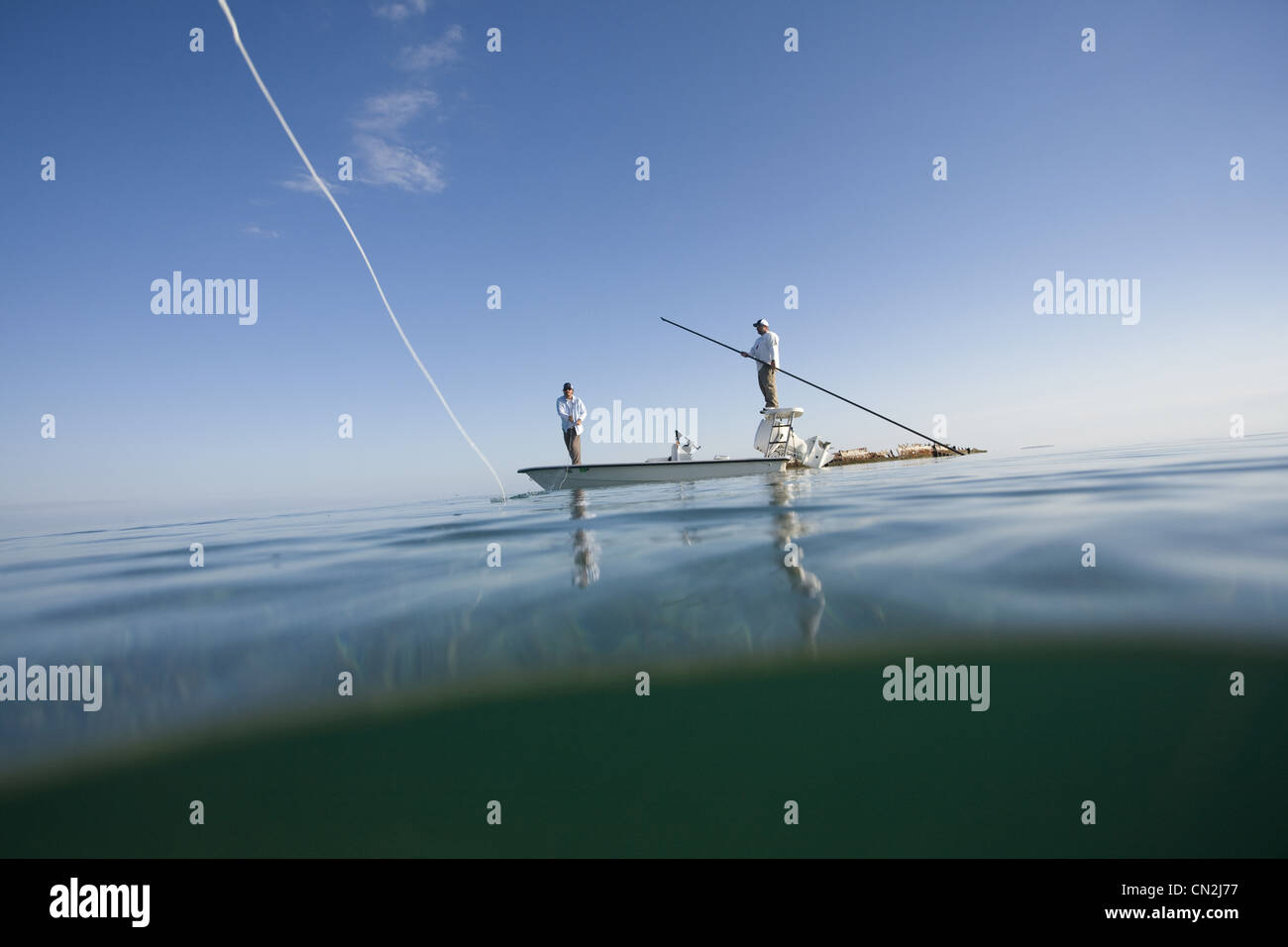 Plus de et sous-Vue de deux hommes La pêche de mouche en bateau près de Shipwreck, Florida Keys, USA Banque D'Images