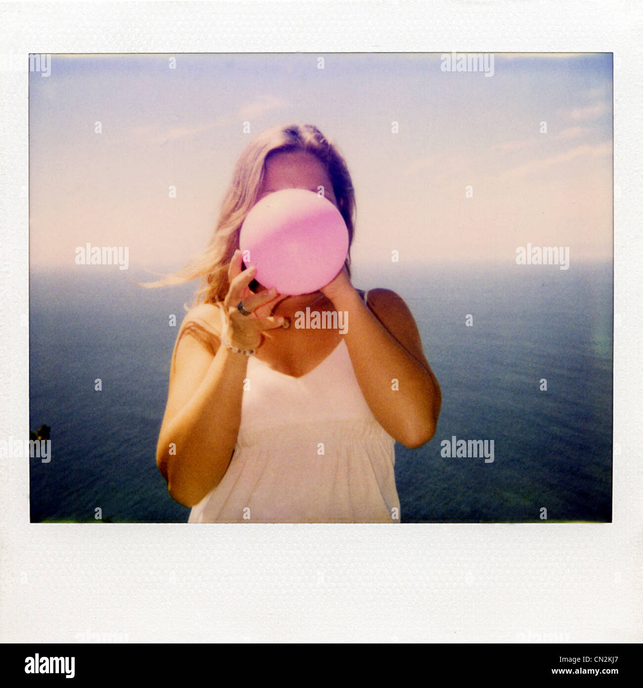 Photographie instantanée film de woman Blowing up balloon Banque D'Images