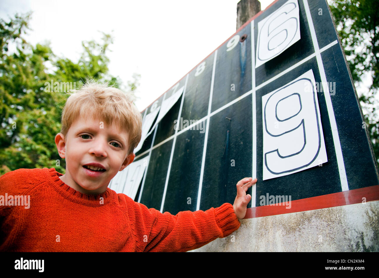 Jeune garçon jouant avec des numéros sur tableau de bord Banque D'Images