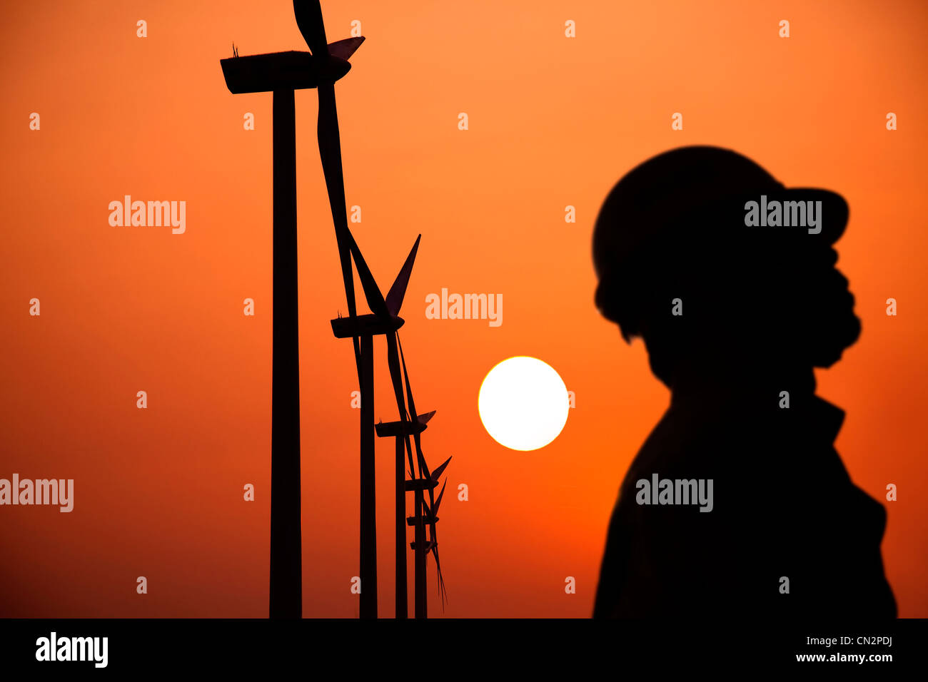 La silhouette des moulins à vent avec travailleur coucher du soleil Banque D'Images