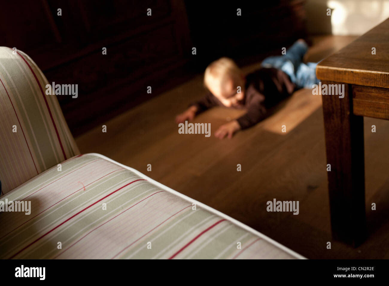 Toddler boy lying on floor Banque D'Images