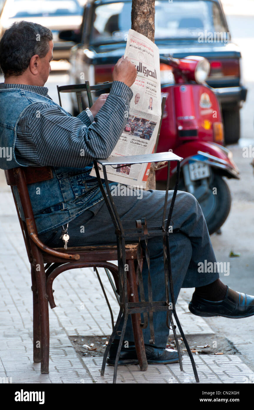 Man reading newspaper centre-ville du Caire Banque D'Images