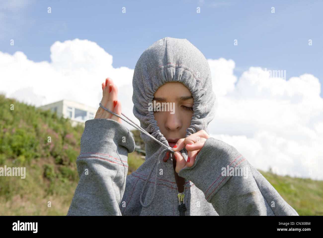 Teenage girl wearing hooded top gris Banque D'Images