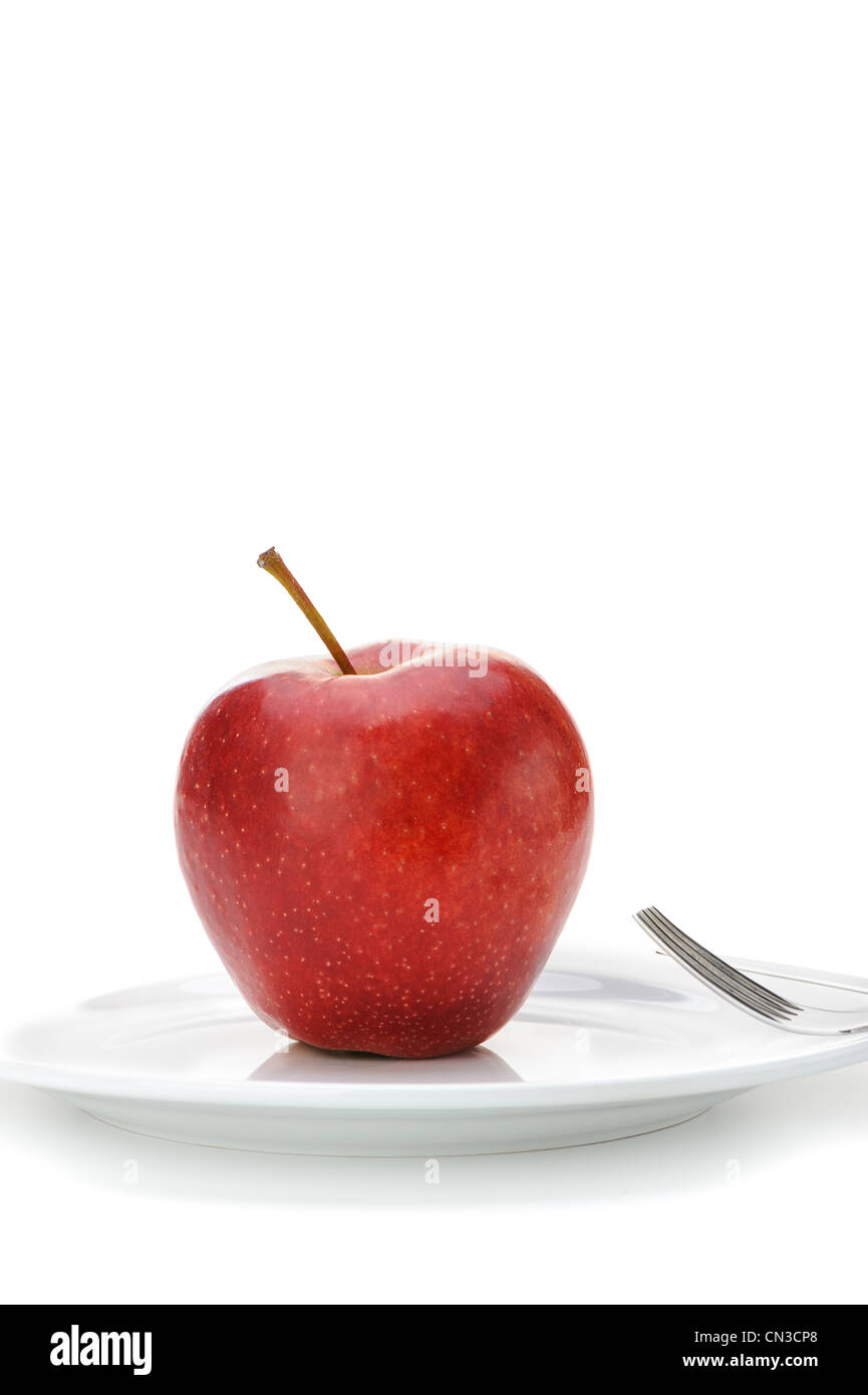 Red apple.Fruits sur une assiette avec une fourchette isolé sur fond blanc Banque D'Images