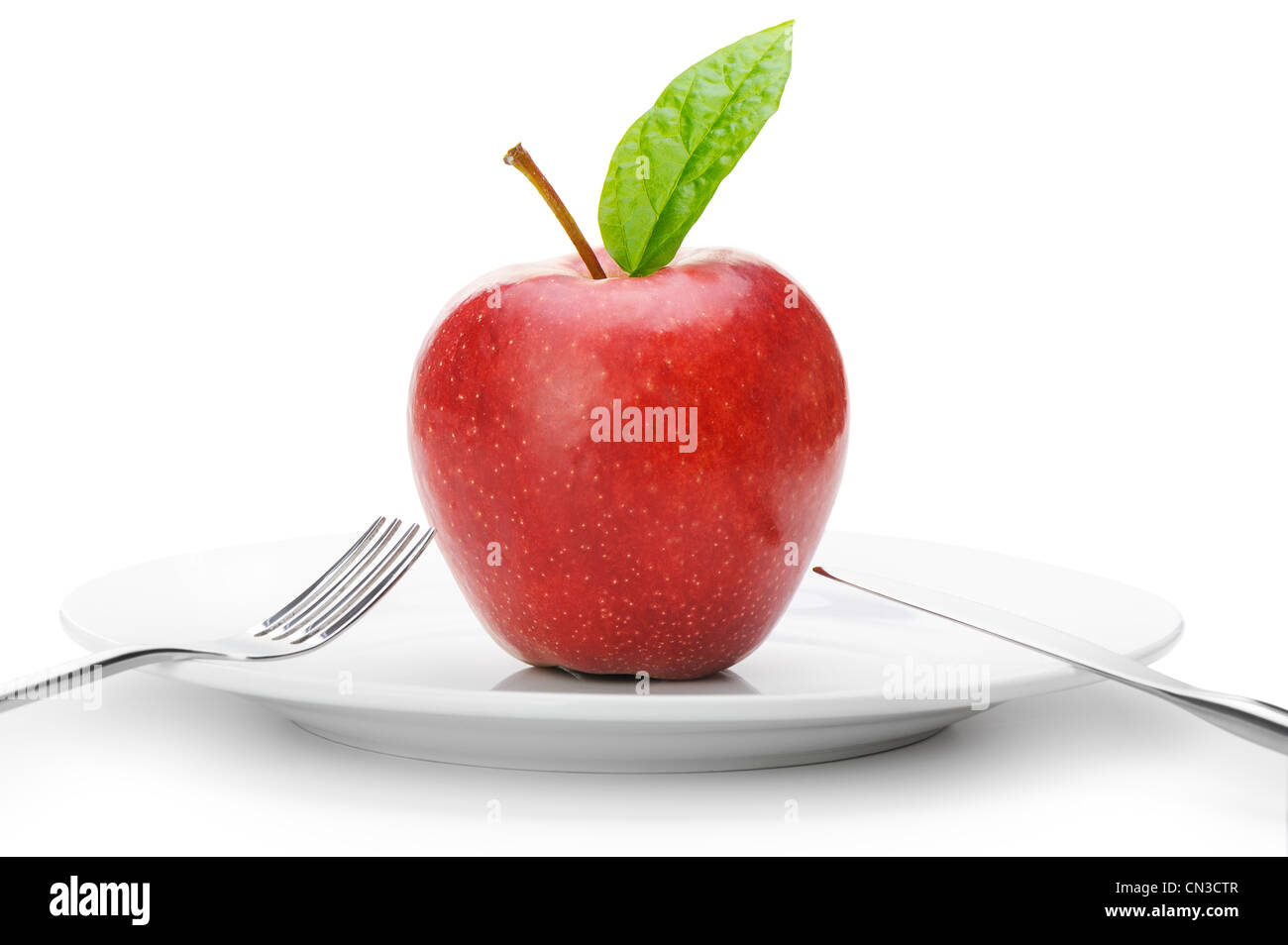 Red apple.Fruits sur une assiette avec une fourchette et couteau isolé sur fond blanc Banque D'Images