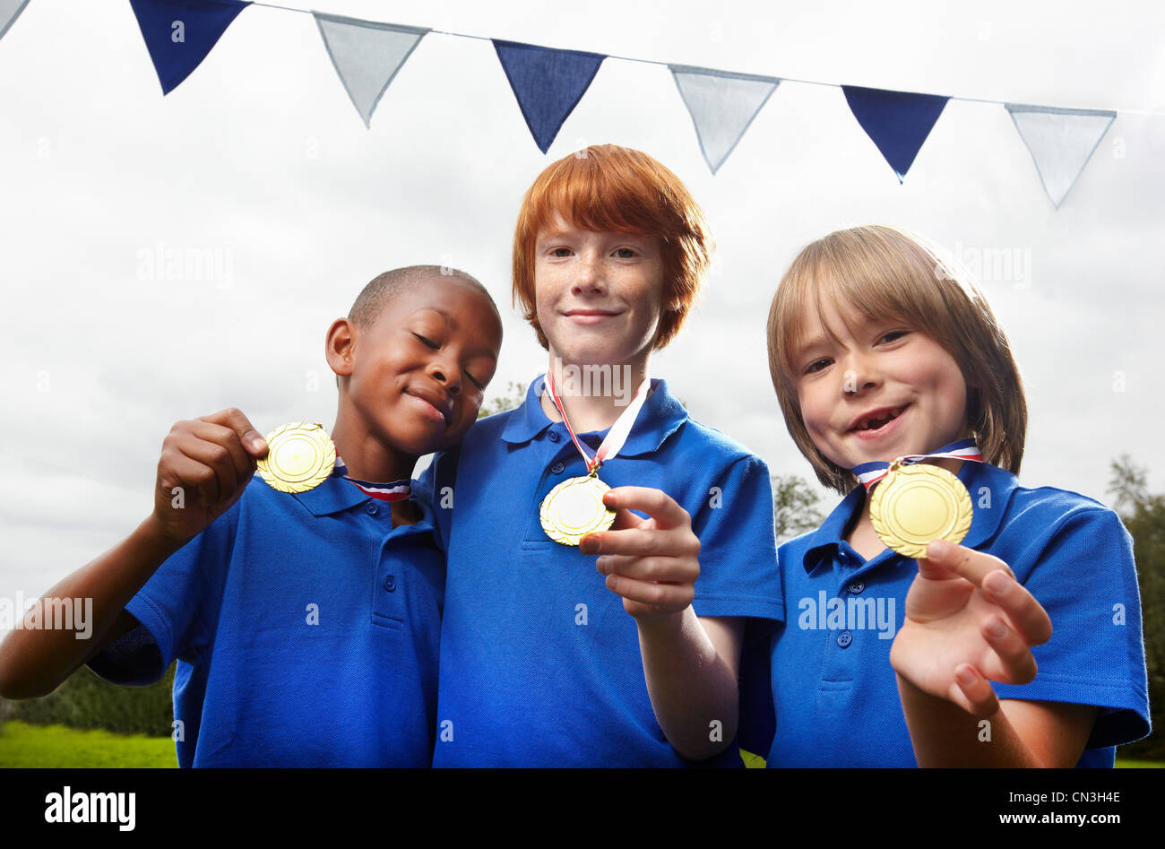 École des garçons holding médailles pour exploit sportif Banque D'Images