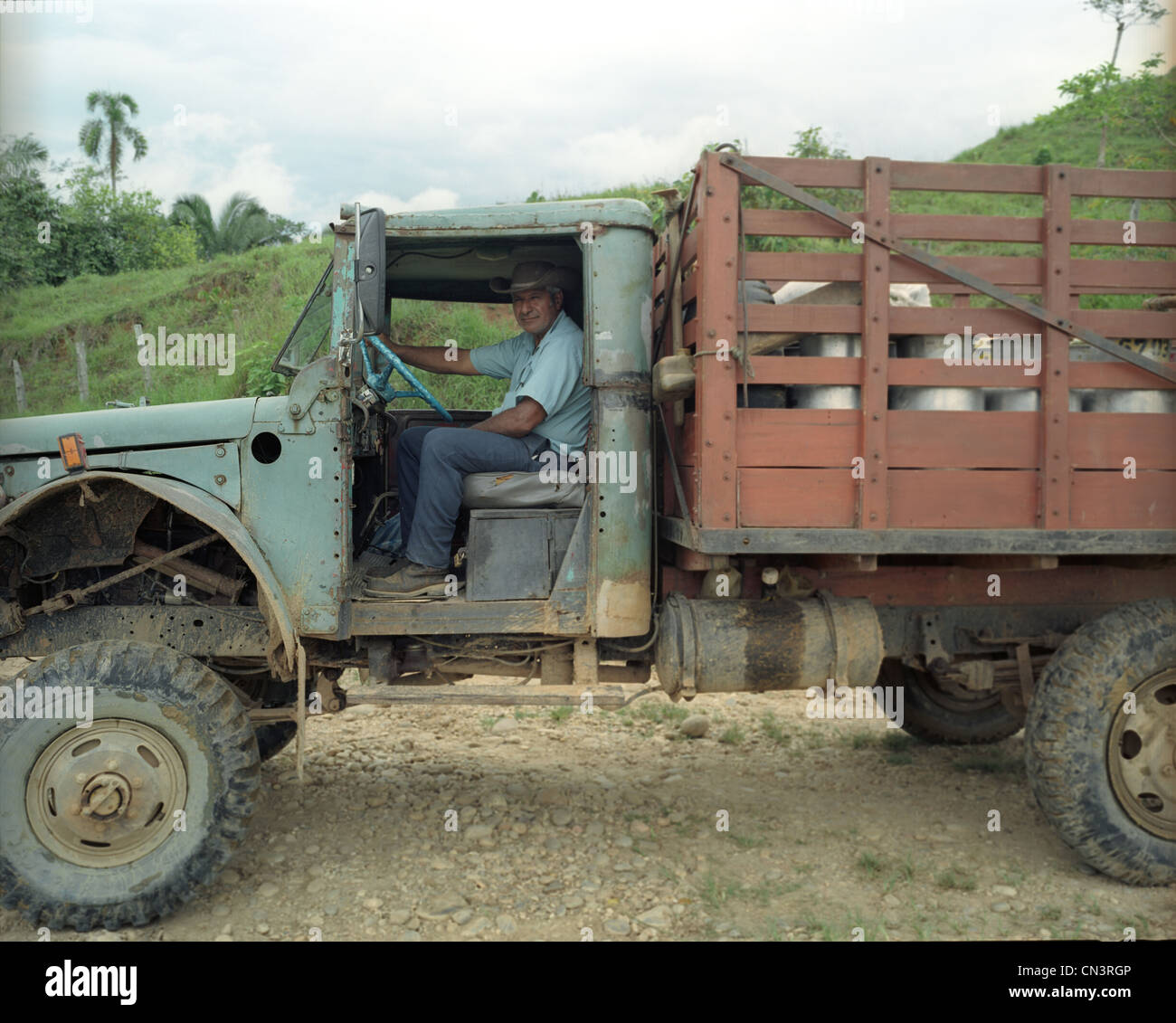 L'homme souriant assis dans un vieux camion agricole Banque D'Images