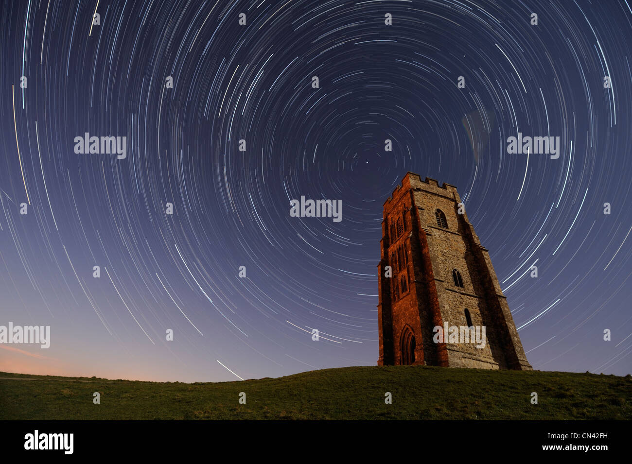 L'exposition d'une heure de Tor de Glastonbury, Somerset, montrant star trails tourbillonner dans le ciel au-dessus de St Michael's Tower. Banque D'Images