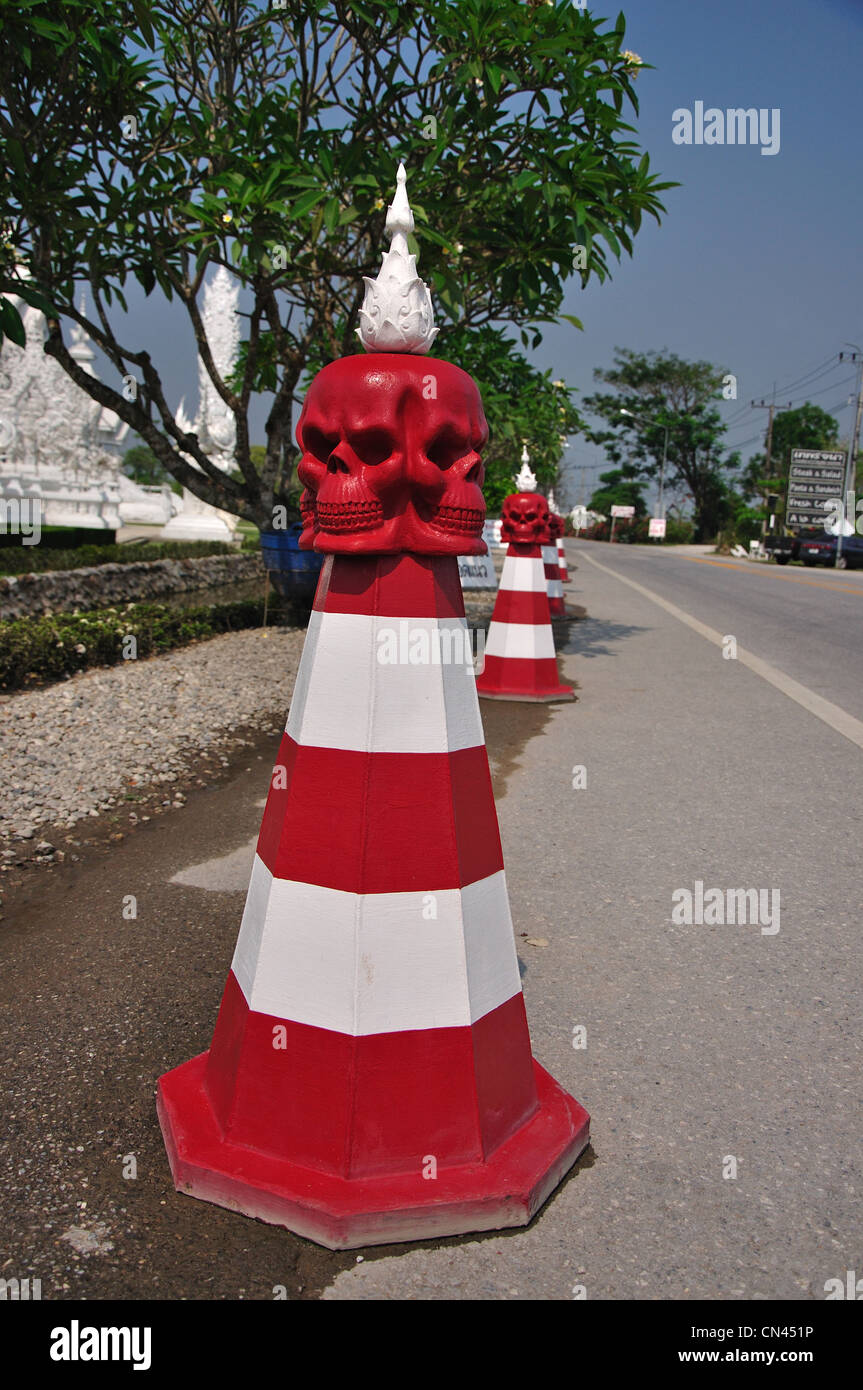 Bornes de route avec têtes de mort par le Wat Rong Khun, temple Chiang Rai, la province de Chiang Rai, Thaïlande Banque D'Images