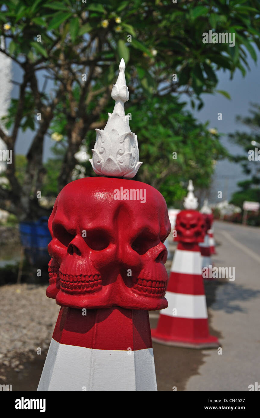 Bornes de route avec têtes de mort par le Wat Rong Khun, temple Chiang Rai, la province de Chiang Rai, Thaïlande Banque D'Images