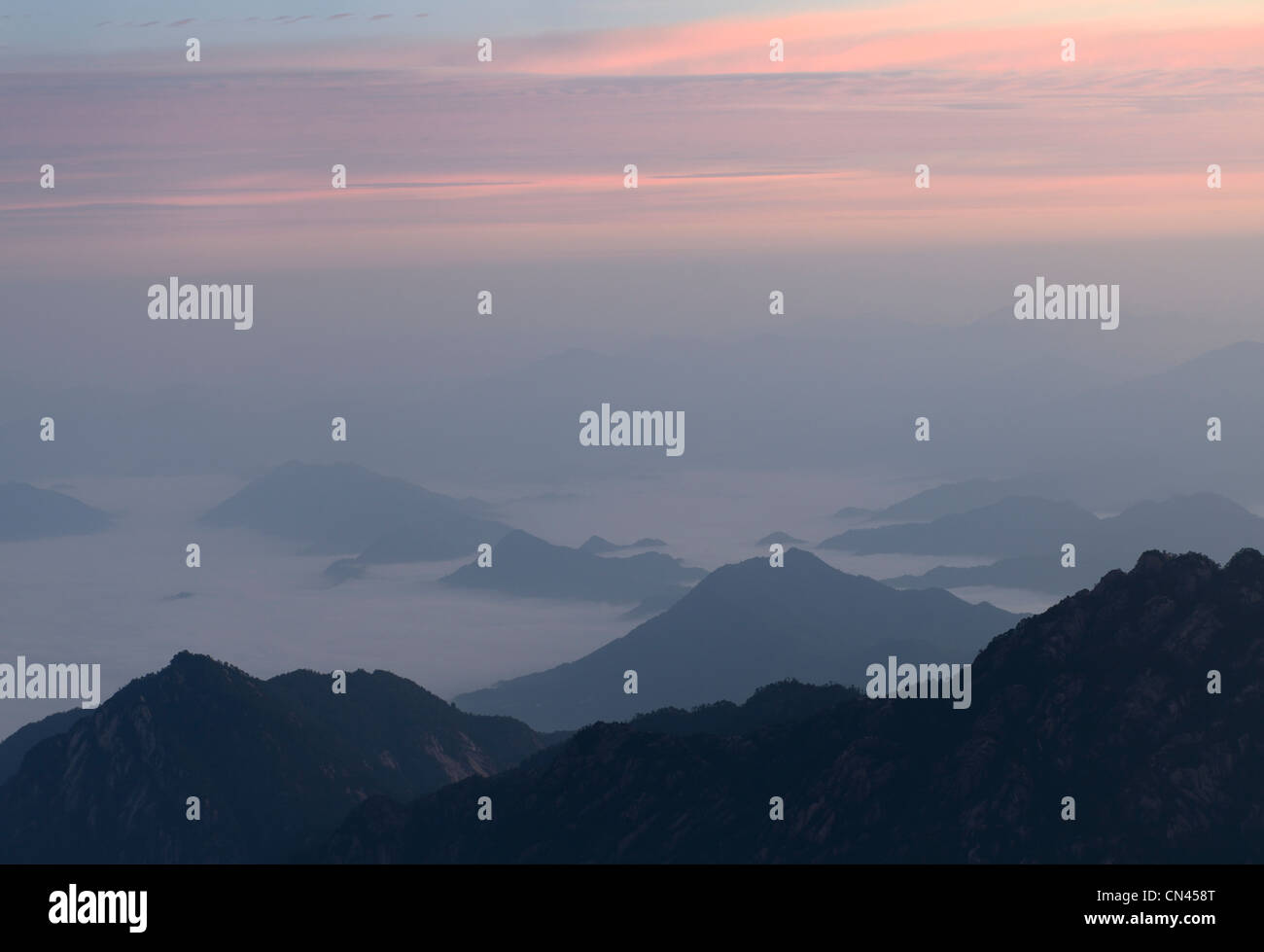 Lueur rose au lever du soleil avec du brouillard en vallée à la mer du Nord, la montagne jaune Huangshan République populaire de Chine Banque D'Images