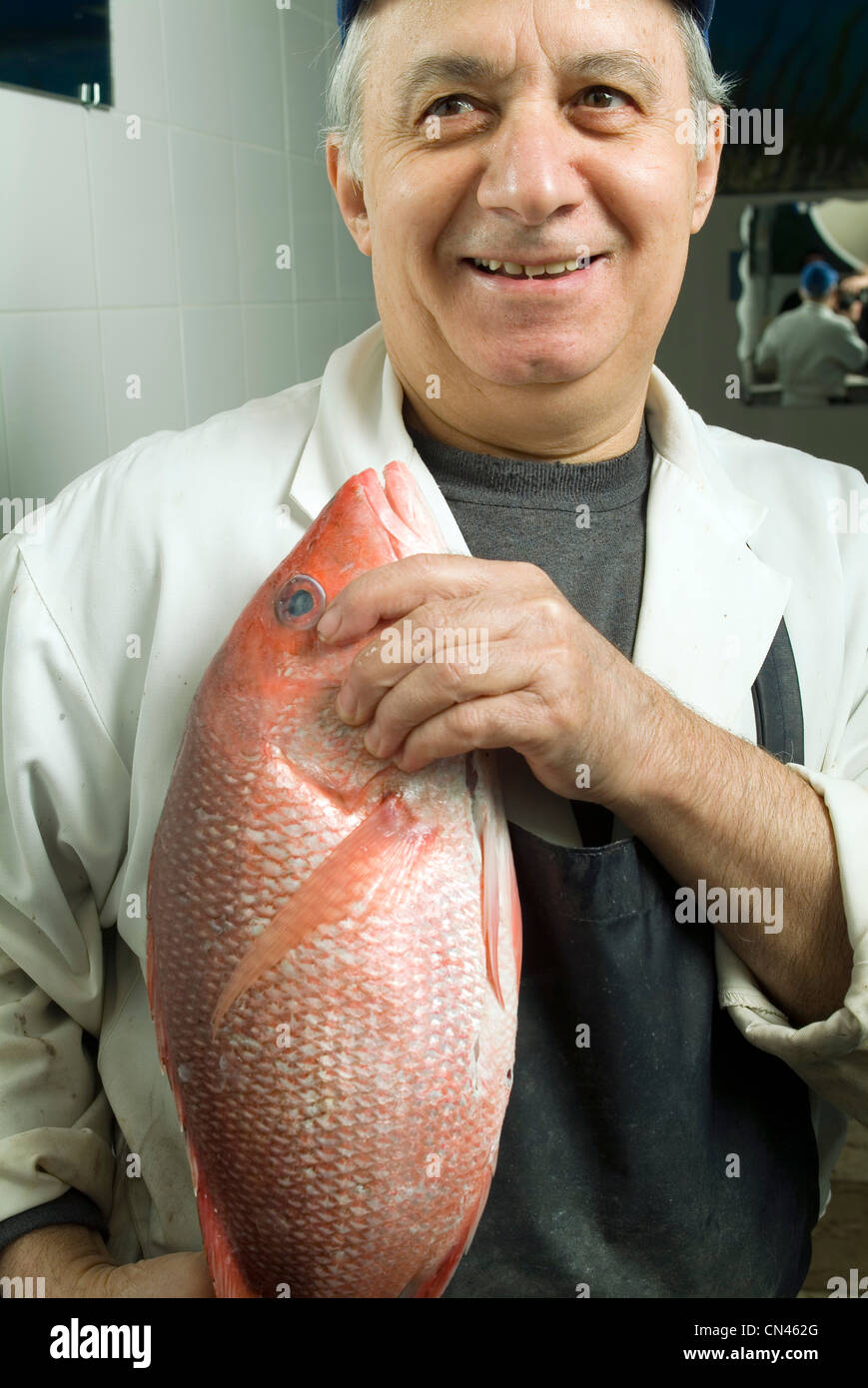 Portrait d'un poissonnier tenant un poisson frais, Montréal, Québec Banque D'Images