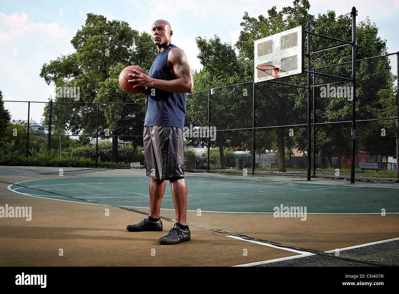 Jeune homme tenant en cour de basket-ball Banque D'Images