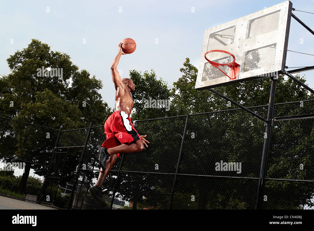 Jeune homme sautant au basket-ball Banque D'Images