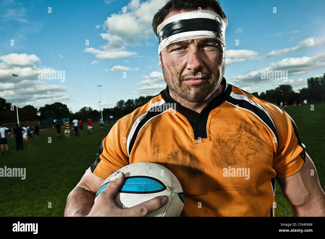 Rugby player holding ball le pitch, portrait Banque D'Images