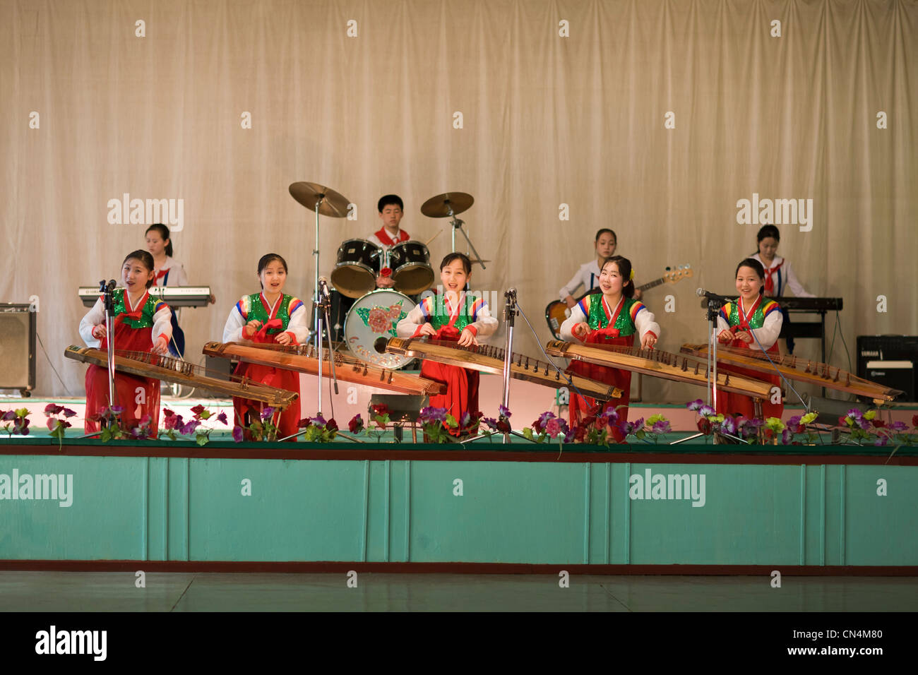 La Corée du Nord, Pyongyang, jeunes filles jouant un instrument de musique à cordes traditionnel coréen (kayageum) à un spectacle de jeunes Banque D'Images