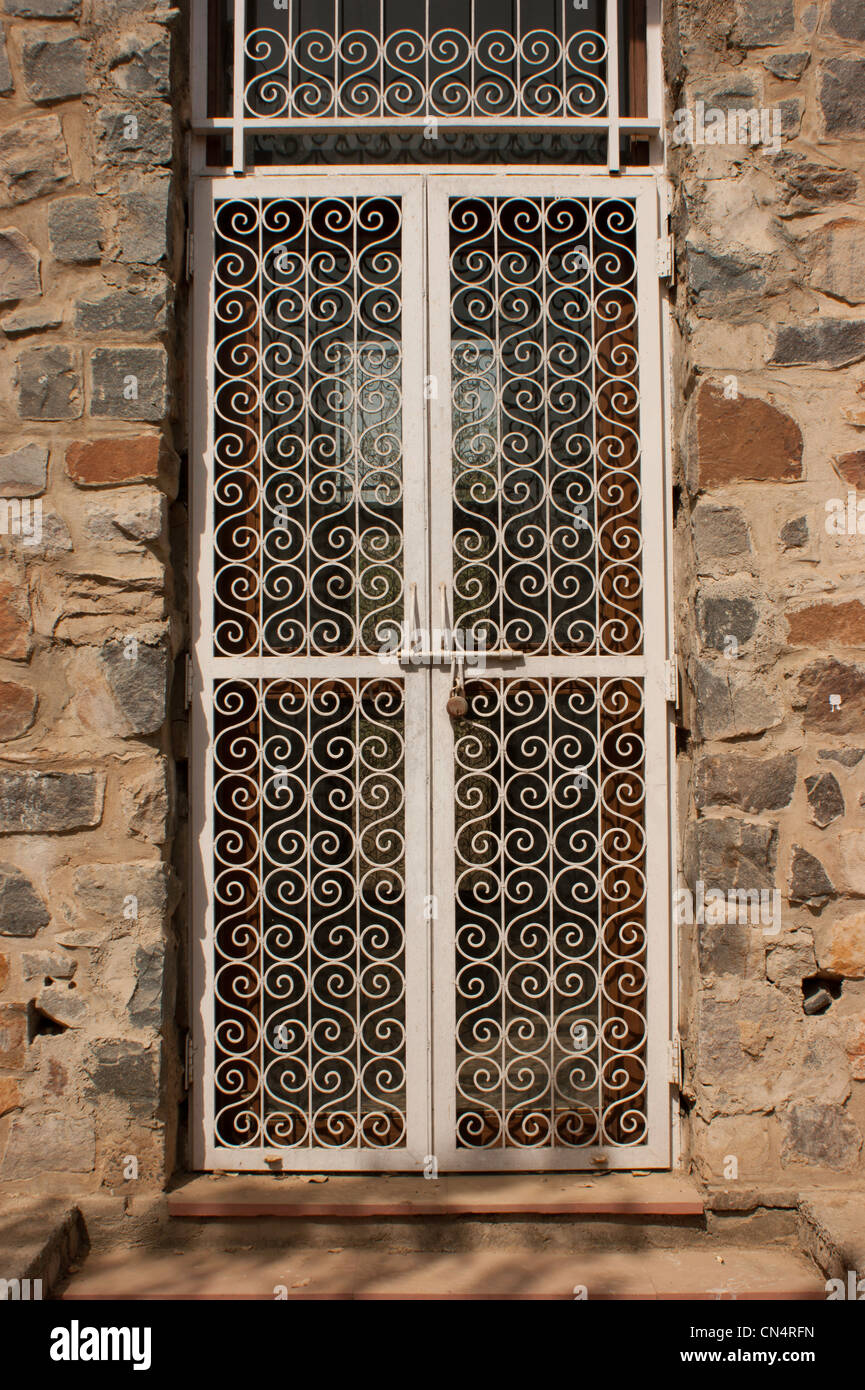 Porte en métal et en pierre. La porte est en fait plus comme une grille avec un motif sur le métal de la porte. Banque D'Images
