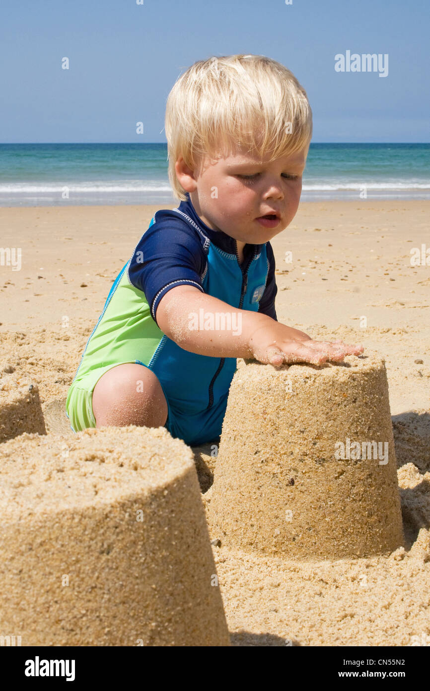 Jeune garçon joue sur la plage en été, une maison européenne Banque D'Images