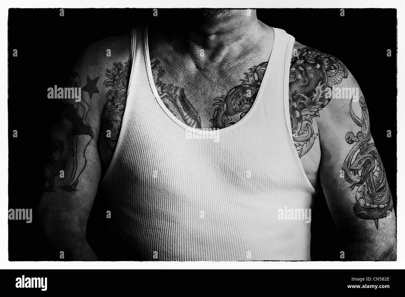Poitrine tourné en noir et blanc de l'homme tattooed man en t-shirt. Banque D'Images
