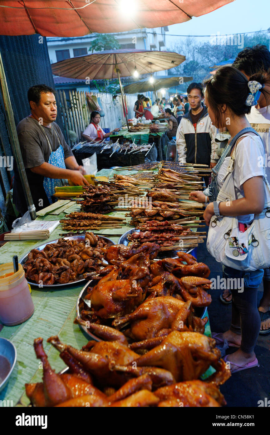 Laos, Luang Prabang Province, La ville de Luang Prabang, le marché de l'alimentation pendant la nuit, à l'étalage et les cuisses de canard laqué du vendeur Banque D'Images