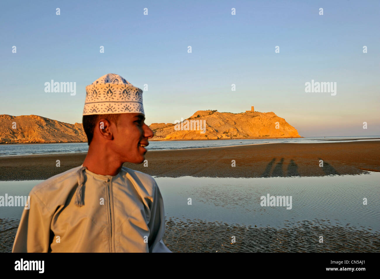 Sultanat d'Oman, Al Batinah Région, Al Sawadi, la plage, le jeune homme à la dichdacha (thawb ou thobe) et traditionnelles (koumma Banque D'Images