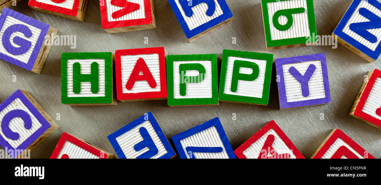Des cales en bois formant le mot heureux dans le centre Banque D'Images